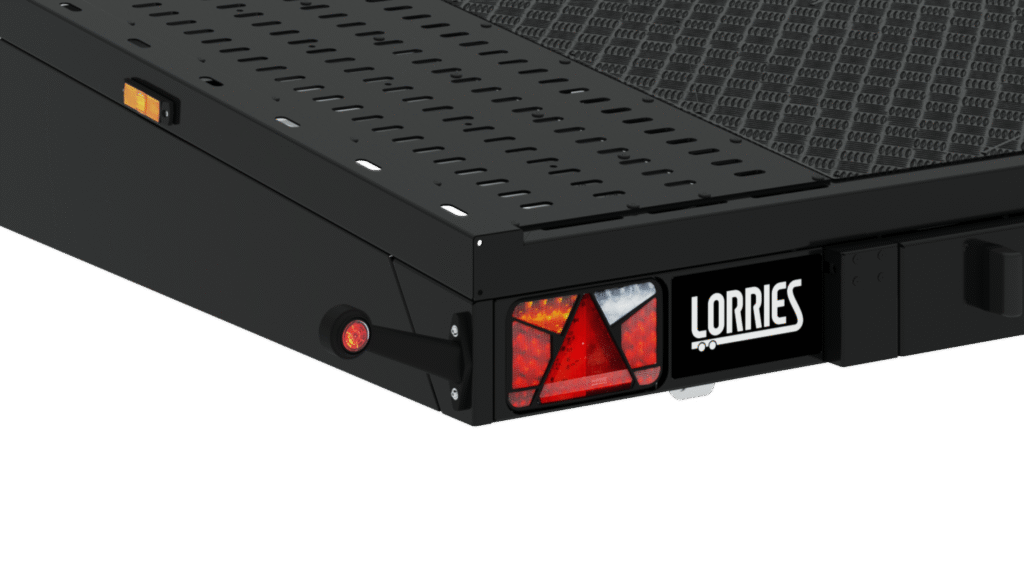 Gros plan de l'angle arrière de la remorque PLS35-6021 BLACK EDITION, montrant un feu arrière rouge et blanc, un réflecteur orange, un petit feu rouge rond et le logo Lorries sur une étiquette blanche.